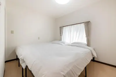 a bedroom with a bed with white sheets and a window at \u53f0\u67713\u4e01\u76ee\u6238\u5efa in Tokyo