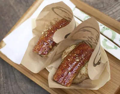 two hot dogs in paper bags on a tray at \u53f0\u67713\u4e01\u76ee\u6238\u5efa in Tokyo