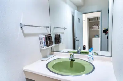 a bathroom with a green sink and a mirror at 6th floor 602 with elevator, 700 meters walk from Nishi-Shinjuku Gochome 4 minutes to Shinjuku, 75 square meters plus 30 square meters of large balcony in Tokyo