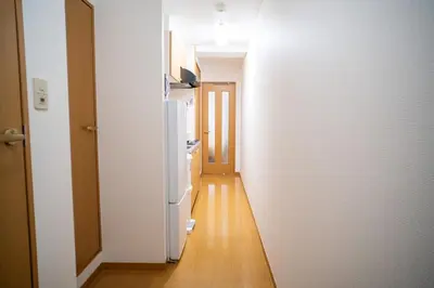 a hallway with a white refrigerator in a room at sitamachi Shin-Koiwa 302 in Tokyo