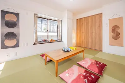 a living room with a wooden table and a window at Akabanestay A \u5fd7\u8302 in Tokyo