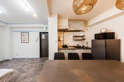 a kitchen and dining room with a table and a refrigerator at R101-Shinjuku 13 minUp to 8 people 60 sqmFull renovationRoppongi and Tsukiji direct accessFamily group7 min to Ochiai Minami-Nagasaki Station in Tokyo