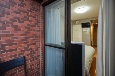 a room with a brick wall and a window at \u65b0\u5bbf\u533a\u6b4c\u821e\u4f0e\u753a\u5f92\u6b65\u4f0a\u52bf\u4e39\u54e5\u65af\u62c9\u623f\u6e9004 in Tokyo
