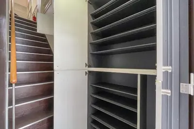 a walk in closet with black shelves at Maison Miyashita in Tokyo