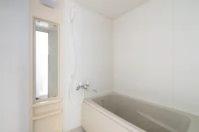 a white bathroom with a tub and a window at Maison Miyashita in Tokyo