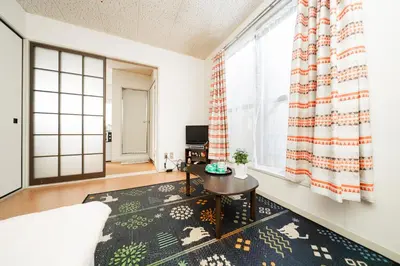 a living room with a table and a window at 2 min walk to Komagome ST 4ppl superior apart in Tokyo