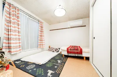 a bedroom with two beds and a window at 2 min walk to Komagome ST 4ppl superior apart in Tokyo