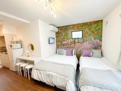 two beds in a room with a painting on the wall at Hotel Ikebukuro Fine Coat in Tokyo