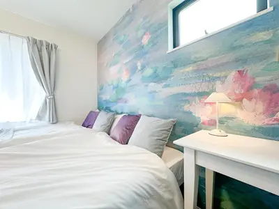 a bedroom with a bed and a painting on the wall at Hotel Ikebukuro Fine Coat in Tokyo