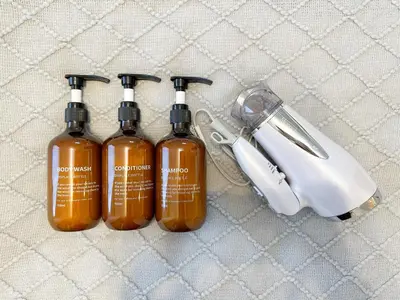 three bottles of alcohol sitting next to a hair dryer at Hotel Ikebukuro Fine Coat in Tokyo