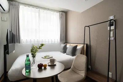 a bedroom with a bed and a table with a bottle at \u30ea\u30a2\u30e9\u30a4\u30ba\u897f\u5c0f\u5c71 in Tokyo
