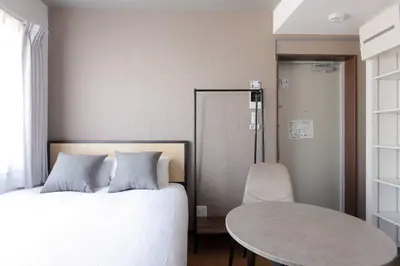 a bedroom with a bed and a table and chair at \u30ea\u30a2\u30e9\u30a4\u30ba\u897f\u5c0f\u5c71 in Tokyo