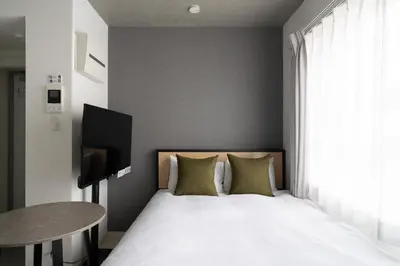 a bedroom with a bed with a table and a television at \u30ea\u30a2\u30e9\u30a4\u30ba\u897f\u5c0f\u5c71 in Tokyo