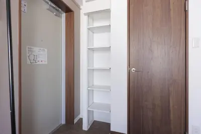 a closet with a wooden door and some shelves at \u30ea\u30a2\u30e9\u30a4\u30ba\u897f\u5c0f\u5c71 in Tokyo