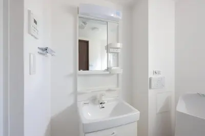a white bathroom with a sink and a mirror at \u30ea\u30a2\u30e9\u30a4\u30ba\u897f\u5c0f\u5c71 in Tokyo