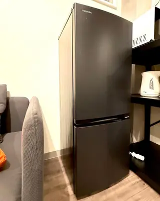 a black refrigerator in the corner of a room at \u9752\u6238\u30aa\u30fc\u30c1\u30e3\u30fc\u30c9\u30d3\u30eb in Tokyo
