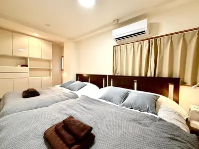 a bedroom with two beds with towels on them at \u9752\u6238\u30aa\u30fc\u30c1\u30e3\u30fc\u30c9\u30d3\u30eb in Tokyo