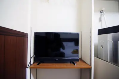 a flat screen tv sitting on top of a wooden shelf at Central Shinjuku, Near Train Station, Quiet Area, No Stairs, Room 102 in Tokyo