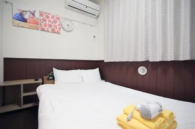 a bedroom with a white bed with a towel on it at Central Shinjuku, Near Train Station, Quiet Area, No Stairs, Room 102 in Tokyo