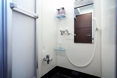 a bathroom with a shower with a sink and a mirror at Central Shinjuku, Near Train Station, Quiet Area, No Stairs, Room 102 in Tokyo