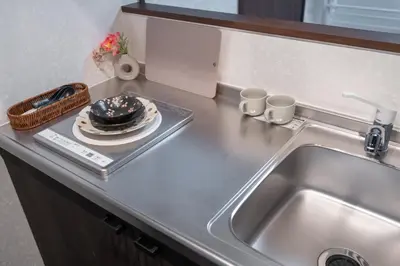 a kitchen counter with a sink and a plate on a tray at ohayo\u4e21\u56fd in Tokyo