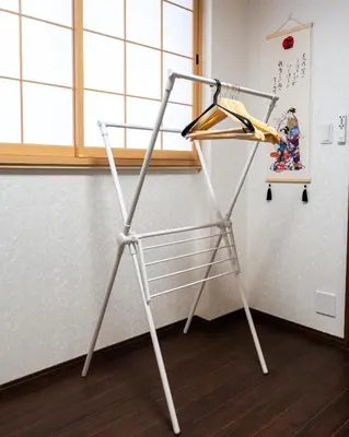 a metal clothes rack in a room with a window at ohayo\u4e21\u56fd in Tokyo