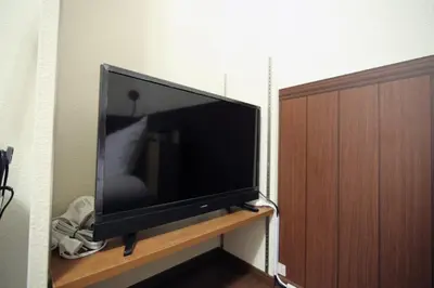 a large flat screen tv sitting on a wooden stand at Quiet Area, Close to Station, Central Shinjuku, Room 202 in Tokyo