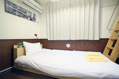 a bedroom with a large white bed and a window at Quiet Area, Close to Station, Central Shinjuku, Room 202 in Tokyo