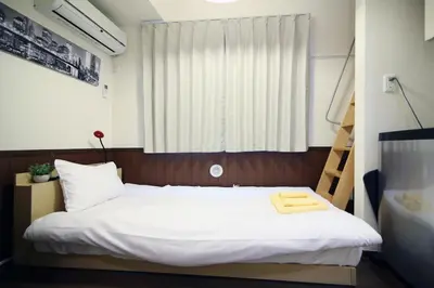 a bedroom with a white bed with a window at Quiet Area, Close to Station, Central Shinjuku, Room 202 in Tokyo