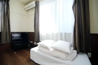 a bed with white sheets and pillows in front of a window at Central Shinjuku, Quiet Area, Close to Station, No Stairs, Room101 in Tokyo