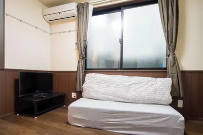 a bedroom with a bed and a window and a television at Central Shinjuku, Quiet Area, Close to Station, No Stairs, Room101 in Tokyo