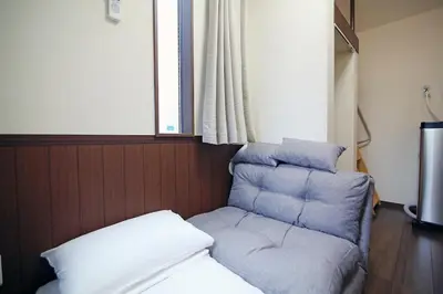a chair and a couch in a room at Central Shinjuku, Quiet Area, Close to Station, Room205 in Tokyo