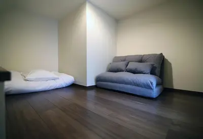a living room with a couch and a bed at Central Shinjuku, Quiet Area, Close to Station, Room205 in Tokyo