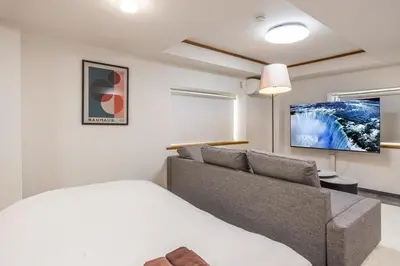 a bedroom with a bed and a couch at R301-Shinjuku 13 min Maximum 8 people 60 sqm Roppongi, Tsukiji direct access Full renovation 7 min walk from Ochiai Minami-Nagasaki Station in Tokyo