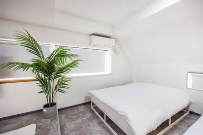 a bedroom with a bed and a potted plant at R301-Shinjuku 13 min Maximum 8 people 60 sqm Roppongi, Tsukiji direct access Full renovation 7 min walk from Ochiai Minami-Nagasaki Station in Tokyo