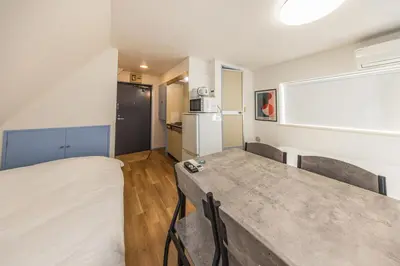 a small room with a table and a refrigerator at R401-Shinjuku 13 minutes Maximum 4 people 30 square meters Full renovation Roppongi and Tsukiji direct access Family group best 7 minutes from Ochiai Minami-Nagasaki Station in Tokyo