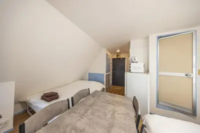 a room with two beds and a table and a refrigerator at R401-Shinjuku 13 minutes Maximum 4 people 30 square meters Full renovation Roppongi and Tsukiji direct access Family group best 7 minutes from Ochiai Minami-Nagasaki Station in Tokyo