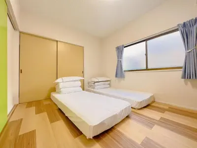 a bedroom with two beds and a window at \u53cb\u7e01\u306e\u5bb6Destined Bonds Haven\u897f\u5de3\u9d28 in Tokyo