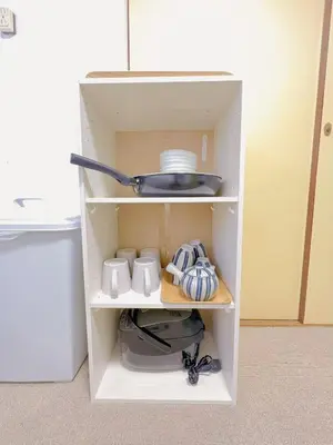 a cupboard with a pot and dishes in it at \u53cb\u7e01\u306e\u5bb6Destined Bonds Haven\u897f\u5de3\u9d28 in Tokyo