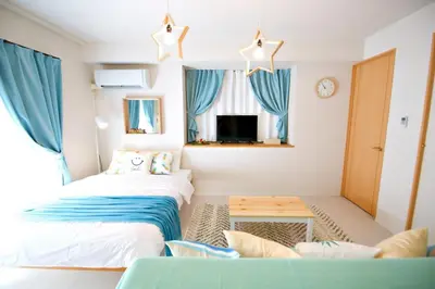 two beds in a room with blue curtains at Regalia Hills Shibuya Dogenzaka - Vacation STAY 18960 in Tokyo