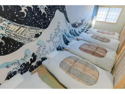 a room with four beds with a painting on the wall at YADOYA Negishi - Vacation STAY 92008v in Tokyo