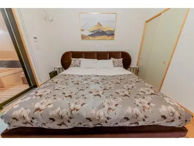 a bed with a white bedspread with flowers on it at YADOYA Yanagitori West - Vacation STAY 92053v in Tokyo