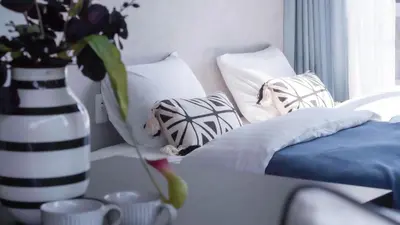 a room with a couch with pillows and a vase with flowers at LANG HOTEL Asakusa#Senso-ji Temple#1Floor 1Room 85m2# Max 8ppl in Tokyo