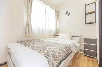 a bedroom with two beds and a window at Nogata Station 3 minutes on foot , 15 minutes to Shinjuku in Tokyo