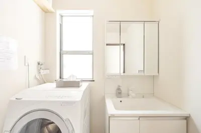 a white laundry room with a washing machine and a sink at Nogata Station 3 minutes on foot , 15 minutes to Shinjuku in Tokyo