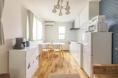 a kitchen with white cabinets and a table and chairs at Nogata Station 3 minutes on foot , 15 minutes to Shinjuku in Tokyo