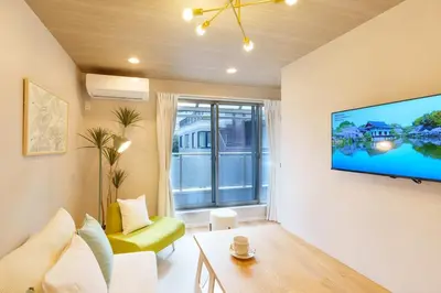 a living room with a large flat screen tv on a wall at \u5922\u306e\u5bbf \u7a42\u7a7a 123t in Tokyo