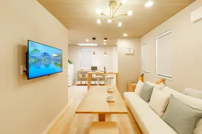 a living room with a couch and a tv on a wall at \u5922\u306e\u5bbf \u7a42\u7a7a 123t in Tokyo