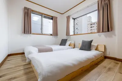 two beds in a room with two windows at Shibuya-honmachi 2-3f in Tokyo