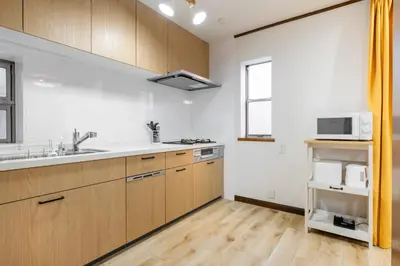 a kitchen with wooden cabinets and a sink and a microwave at Shibuya-honmachi 2-3f in Tokyo